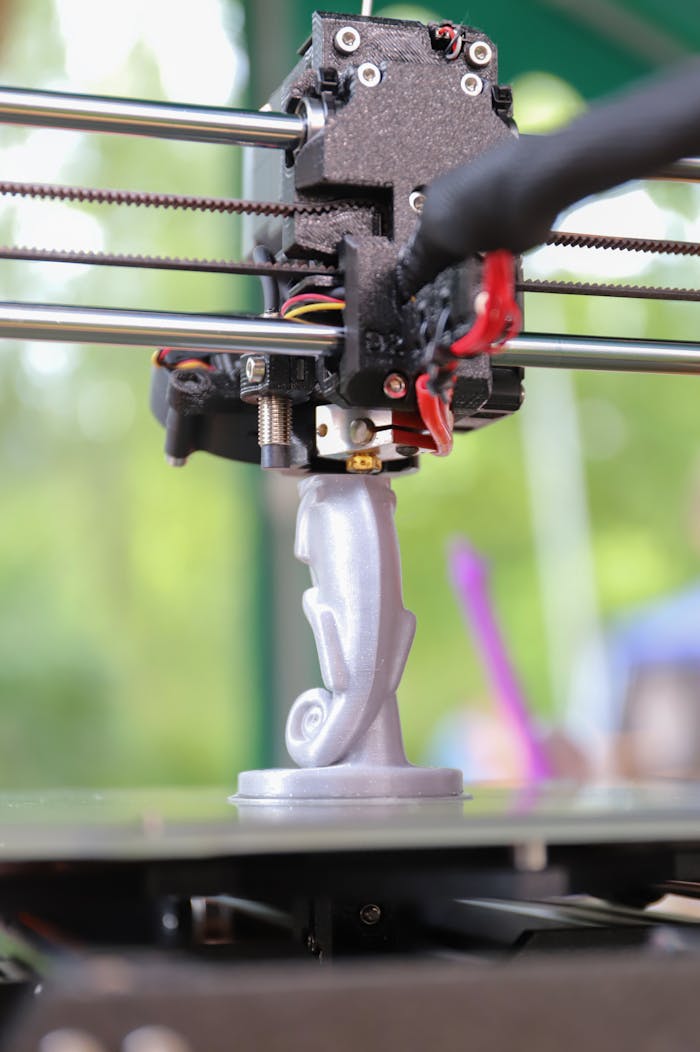 Close-up of a 3D printer creating a decorative figurine, showcasing modern technology in action.
